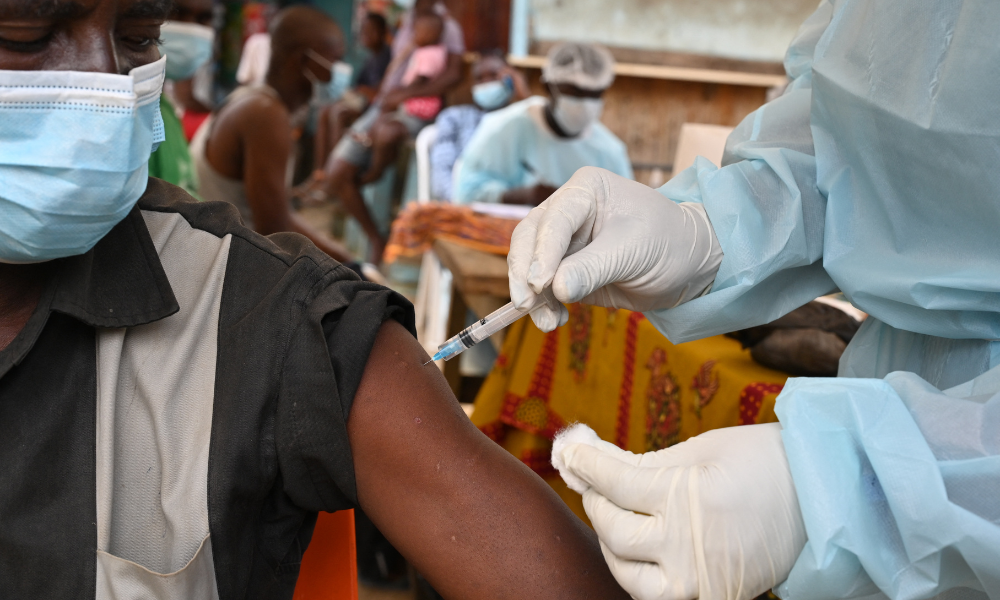 Um profissional de saúde vacina um homem em Abidjan, em 17 de agosto de 2021, durante uma campanha de vacinação contra o Ebola, após o país registrar seu primeiro caso conhecido da doença desde 1994. (Foto de Issouf Sanogo / AFP)
