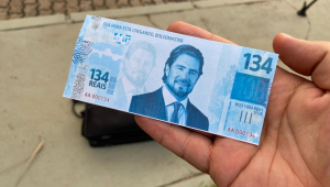 Protesto na casa de Flávio tem marcha fúnebre e ‘chuva’ de nota de R$ 134; veja vídeo